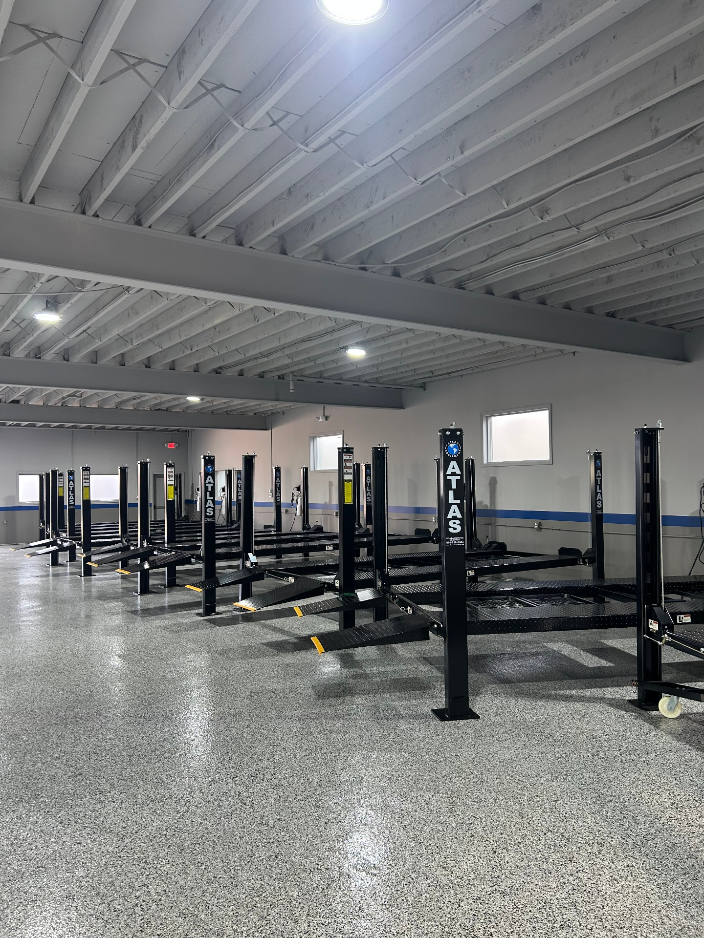Row of Atlas four-post storage lifts installed in a warehouse