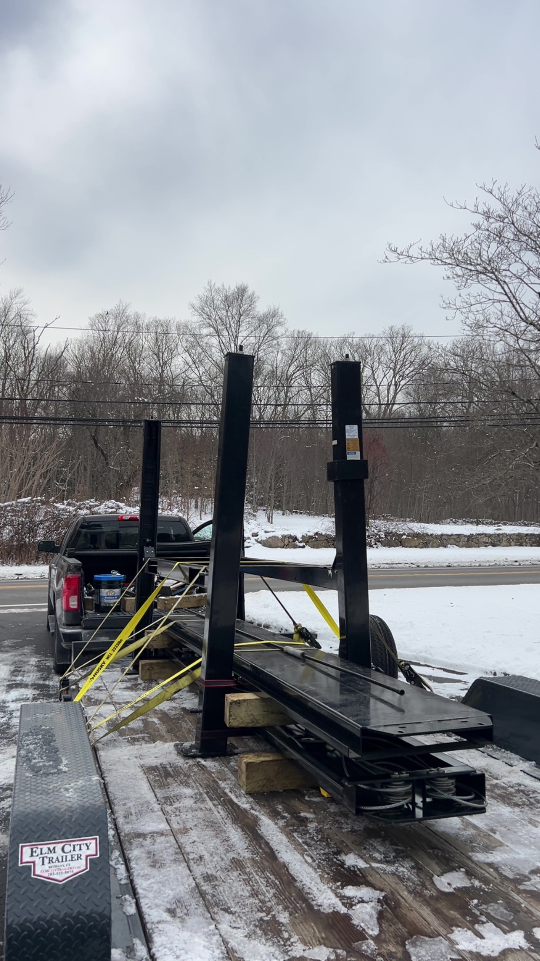 Two-post lift columns loaded on an Elm City trailer in the snow