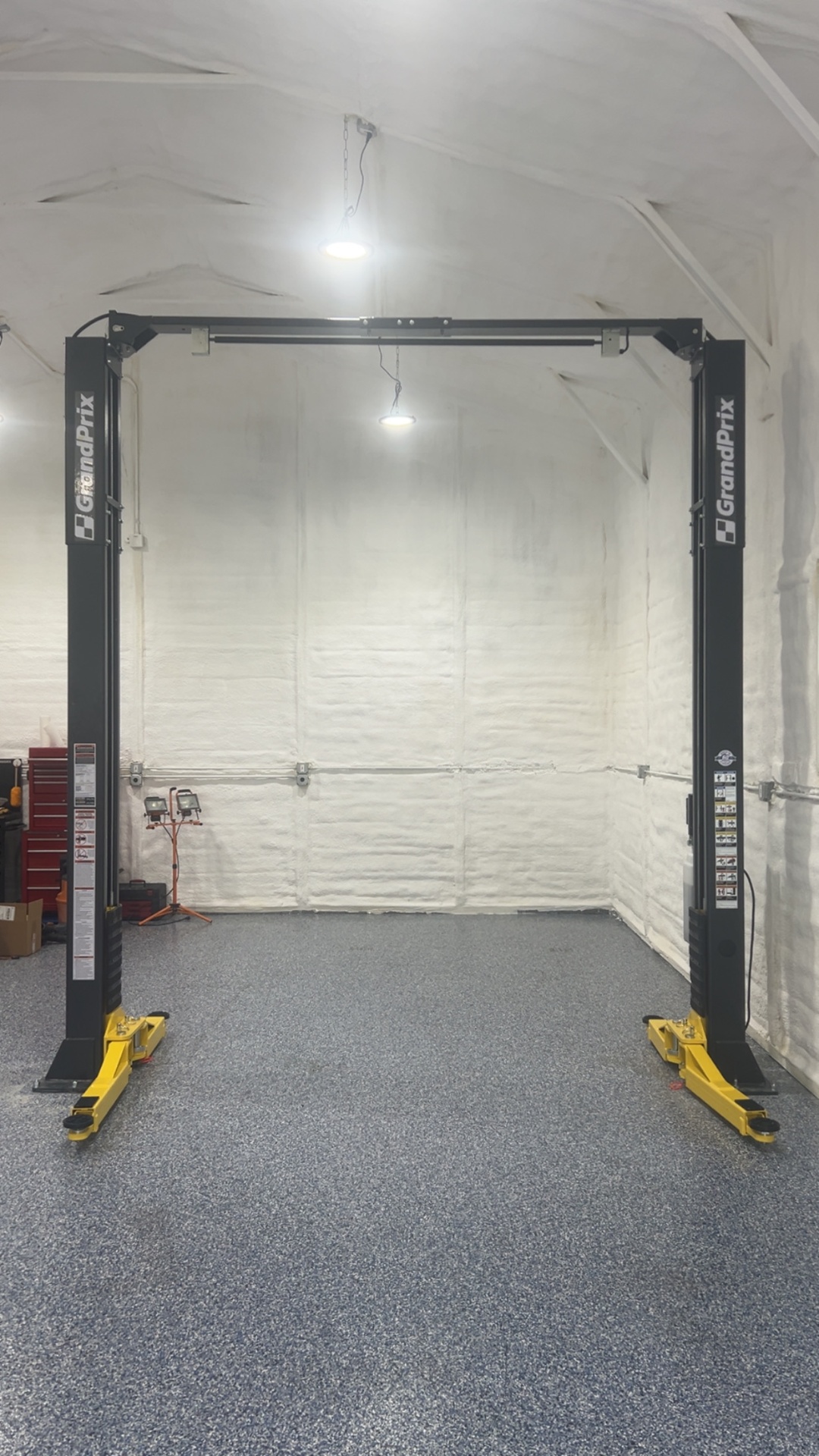 GrandPrix two-post lift freshly installed on epoxy floor